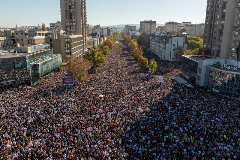 Pemandangan drone menunjukkan orang-orang berdiam diri selama 16 menit di luar stasiun kereta api Novi Sad selama upacara peringatan, pada peringatan pertama runtuhnya kanopi stasiun yang fatal pada November 2024, yang menewaskan 16 orang, memicu tuduhan nasional tentang korupsi dan kelalaian yang meluas, di Novi Sad, Serbia, 1 November 2025. (REUTERS/Marko Djurica)