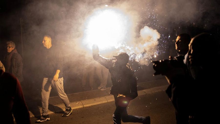 Seorang demonstran antipemerintah memberi isyarat di depan petugas penegak hukum dengan perlengkapan anti huru hara di dekat parlemen di Beograd, Serbia, 2 November 2025. (REUTERS/Marko Djurica)