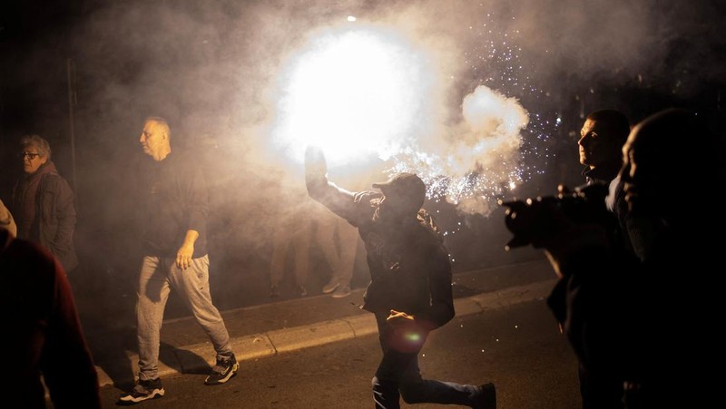 Seorang demonstran antipemerintah memberi isyarat di depan petugas penegak hukum dengan perlengkapan anti huru hara di dekat parlemen di Beograd, Serbia, 2 November 2025. (REUTERS/Marko Djurica)