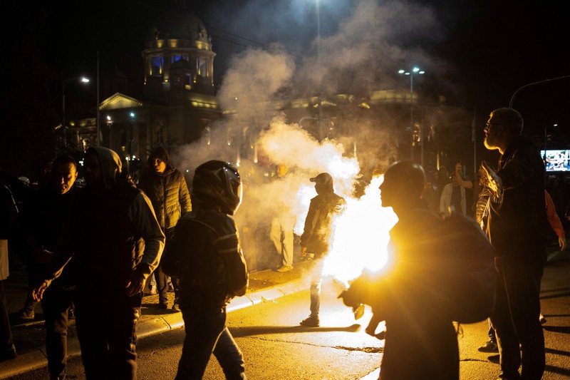 Seorang demonstran antipemerintah memberi isyarat di depan petugas penegak hukum dengan perlengkapan anti huru hara di dekat parlemen di Beograd, Serbia, 2 November 2025. (REUTERS/Marko Djurica)
