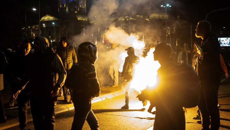 Seorang demonstran antipemerintah memberi isyarat di depan petugas penegak hukum dengan perlengkapan anti huru hara di dekat parlemen di Beograd, Serbia, 2 November 2025. (REUTERS/Marko Djurica)