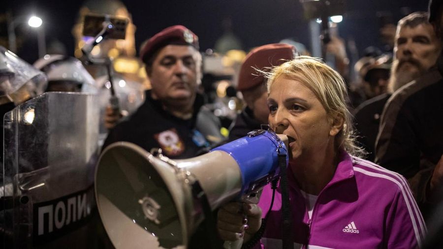 Seorang demonstran antipemerintah memberi isyarat di depan petugas penegak hukum dengan perlengkapan anti huru hara di dekat parlemen di Beograd, Serbia, 2 November 2025. (REUTERS/Marko Djurica)