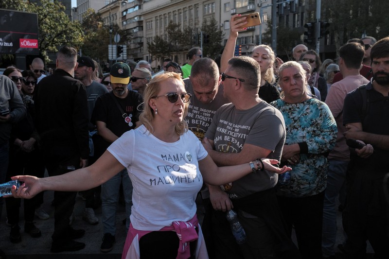 Seorang demonstran antipemerintah memberi isyarat di depan petugas penegak hukum dengan perlengkapan anti huru hara di dekat parlemen di Beograd, Serbia, 2 November 2025. (REUTERS/Marko Djurica)