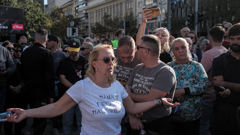 Seorang demonstran antipemerintah memberi isyarat di depan petugas penegak hukum dengan perlengkapan anti huru hara di dekat parlemen di Beograd, Serbia, 2 November 2025. (REUTERS/Marko Djurica)