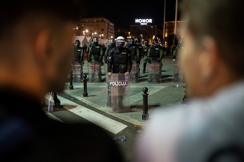 Seorang demonstran antipemerintah memberi isyarat di depan petugas penegak hukum dengan perlengkapan anti huru hara di dekat parlemen di Beograd, Serbia, 2 November 2025. (REUTERS/Marko Djurica)