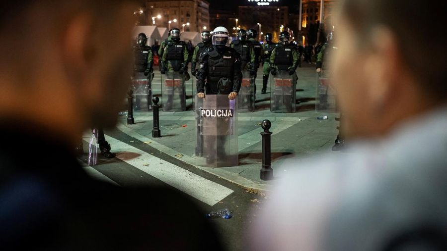 Seorang demonstran antipemerintah memberi isyarat di depan petugas penegak hukum dengan perlengkapan anti huru hara di dekat parlemen di Beograd, Serbia, 2 November 2025. (REUTERS/Marko Djurica)