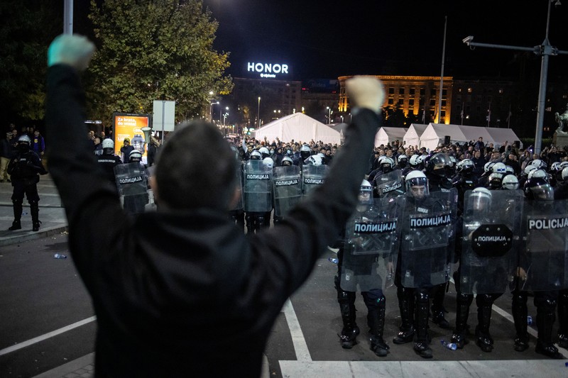 Seorang demonstran antipemerintah memberi isyarat di depan petugas penegak hukum dengan perlengkapan anti huru hara di dekat parlemen di Beograd, Serbia, 2 November 2025. (REUTERS/Marko Djurica)