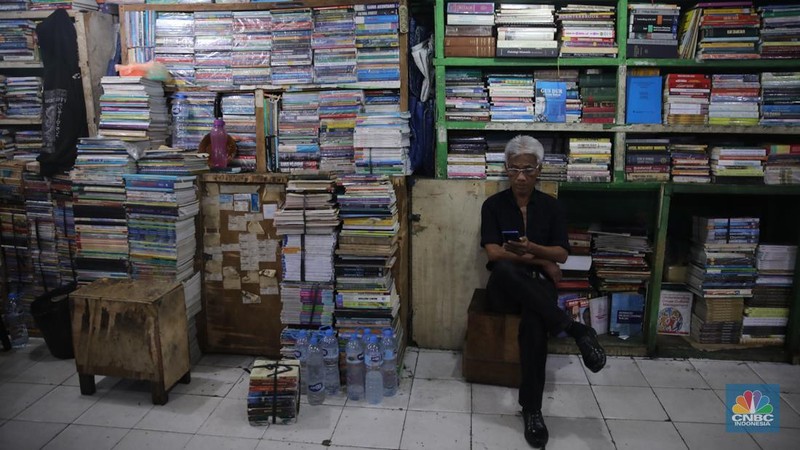 Pedagang buku menunggu pembeli di Sentra Toko Buku Kwitang, Jakarta, Selasa (4/11/2025). Sentra toko buku Kwitang masih cukup eksis meski kondisinya tak seramai dahulu ditengah gempuran marketplace. (CNBC Indonesia/Faisal Rahman)