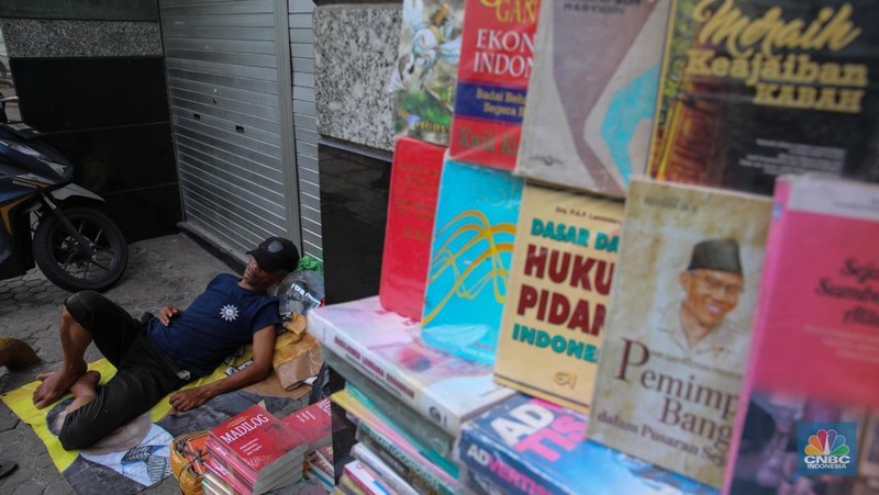 Pedagang buku menunggu pembeli di Sentra Toko Buku Kwitang, Jakarta, Selasa (4/11/2025). Sentra toko buku Kwitang masih cukup eksis meski kondisinya tak seramai dahulu ditengah gempuran marketplace. (CNBC Indonesia/Faisal Rahman)