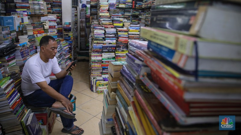 Pedagang buku menunggu pembeli di Sentra Toko Buku Kwitang, Jakarta, Selasa (4/11/2025). Sentra toko buku Kwitang masih cukup eksis meski kondisinya tak seramai dahulu ditengah gempuran marketplace. (CNBC Indonesia/Faisal Rahman)