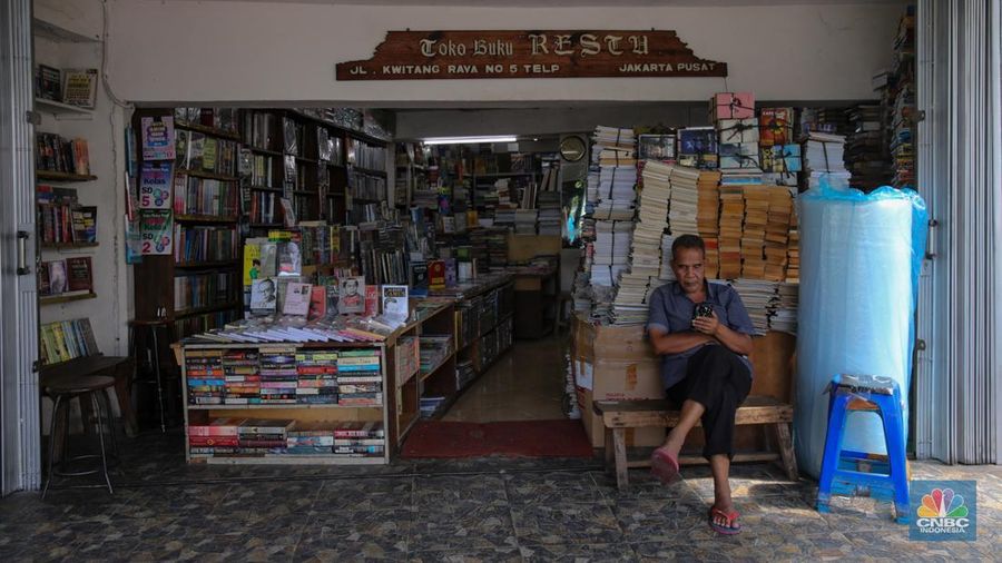 Pedagang buku menunggu pembeli di Sentra Toko Buku Kwitang, Jakarta, Selasa (4/11/2025). Sentra toko buku Kwitang masih cukup eksis meski kondisinya tak seramai dahulu ditengah gempuran marketplace. (CNBC Indonesia/Faisal Rahman)