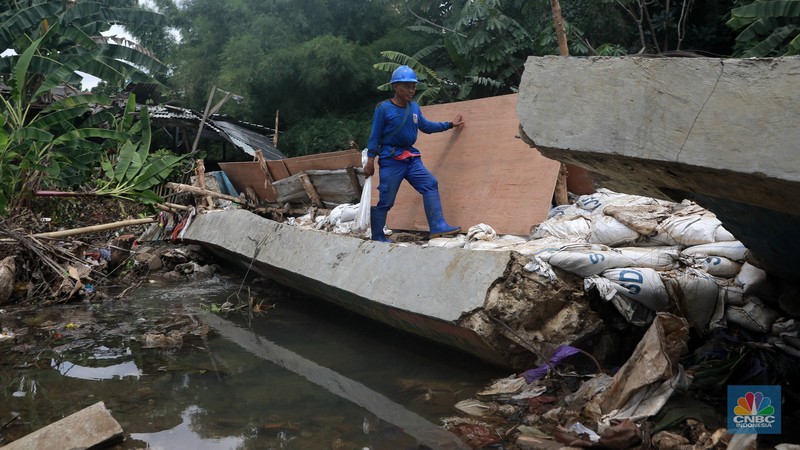 Petugas Dinas SDA menata karung pasir untuk penurapan sementara tanggul Baswedan yang jebol di Jati Padang, Pasar Minggu, Jakarta Selatan, Selasa (4/11/2025). (CNBC Indonesia/Muhammad Sabki)