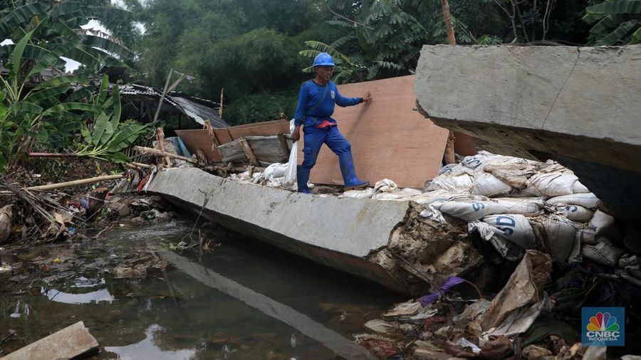 Petugas Dinas SDA menata karung pasir untuk penurapan sementara tanggul Baswedan yang jebol di Jati Padang, Pasar Minggu, Jakarta Selatan, Selasa (4/11/2025). (CNBC Indonesia/Muhammad Sabki)