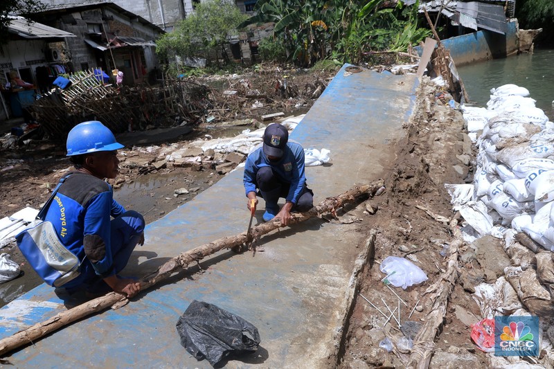 Petugas Dinas SDA menata karung pasir untuk penurapan sementara tanggul Baswedan yang jebol di Jati Padang, Pasar Minggu, Jakarta Selatan, Selasa (4/11/2025). (CNBC Indonesia/Muhammad Sabki)