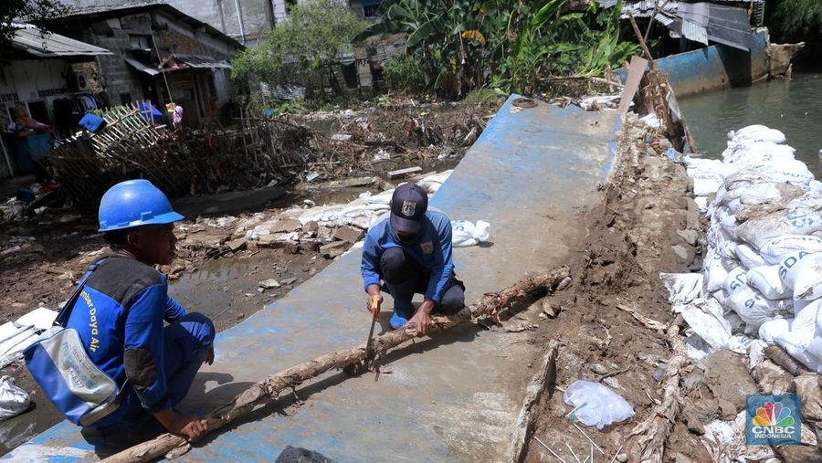 Petugas Dinas SDA menata karung pasir untuk penurapan sementara tanggul Baswedan yang jebol di Jati Padang, Pasar Minggu, Jakarta Selatan, Selasa (4/11/2025). (CNBC Indonesia/Muhammad Sabki)