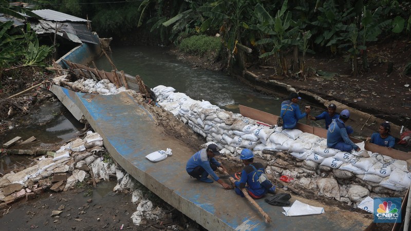 Petugas Dinas SDA menata karung pasir untuk penurapan sementara tanggul Baswedan yang jebol di Jati Padang, Pasar Minggu, Jakarta Selatan, Selasa (4/11/2025). (CNBC Indonesia/Muhammad Sabki)