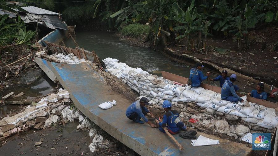 Petugas Dinas SDA menata karung pasir untuk penurapan sementara tanggul Baswedan yang jebol di Jati Padang, Pasar Minggu, Jakarta Selatan, Selasa (4/11/2025). (CNBC Indonesia/Muhammad Sabki)