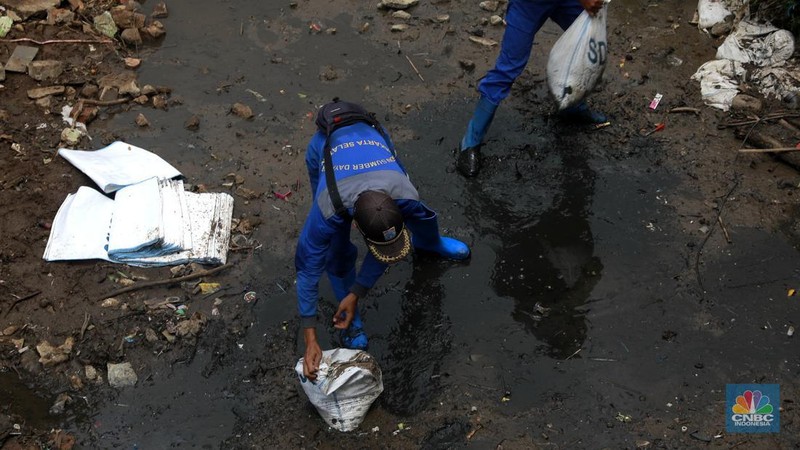 Petugas Dinas SDA menata karung pasir untuk penurapan sementara tanggul Baswedan yang jebol di Jati Padang, Pasar Minggu, Jakarta Selatan, Selasa (4/11/2025). (CNBC Indonesia/Muhammad Sabki)