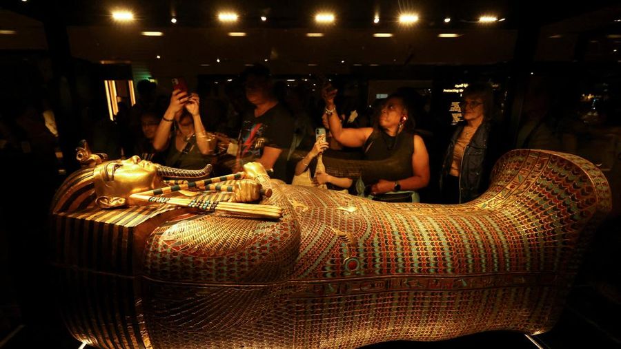 Pengunjung melihat peti mati emas Firaun Mesir kuno Tutankhamun pada hari pertama pengunjung setelah pembukaan resmi Museum Agung Mesir (GEM), dekat kompleks piramida Giza, di Giza, Mesir, 4 November 2025. (REUTERS/Mohamed Abd El Ghany)