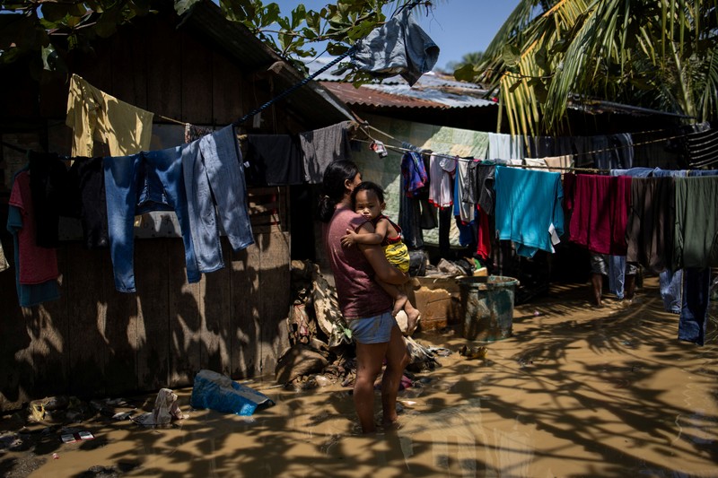 Topan Kalmaegi menerjang wilayah Cebu di Filipina, pada Selasa (4/11) malam. Selain topan, wilayah tersebut juga dilanda hujan deras dan banjir bandang. Rumah warga yang berada di bantaran sungai hancur tersapu derasnya banjir. (REUTERS/Eloisa Lopez)