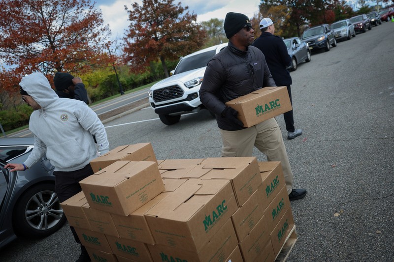 Para relawan memuat kotak-kotak makanan ke dalam mobil selama acara yang diadakan oleh Community FoodBank of New Jersey bekerja sama dengan Bergen County untuk mengirimkan bantuan makanan darurat kepada pekerja Federal dan penerima SNAP di tengah penutupan pemerintah AS di Leonia, New Jersey, AS, 6 November 2025. (REUTERS/Mike Segar)