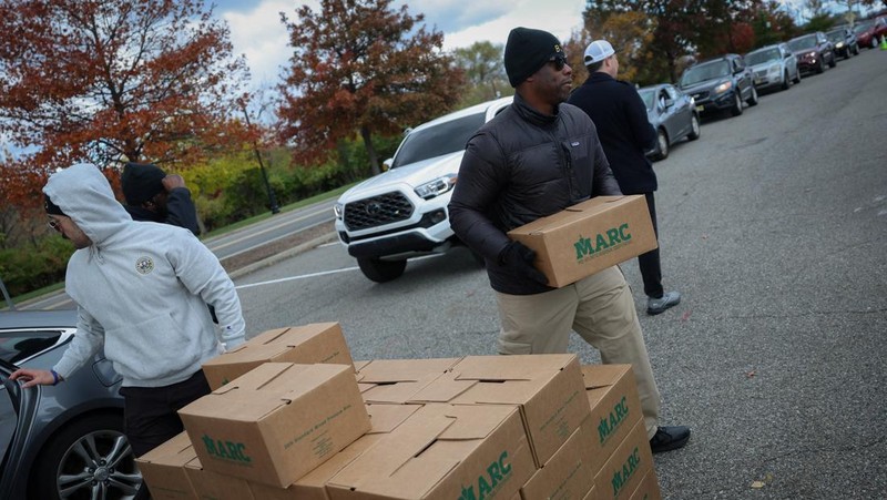 Para relawan memuat kotak-kotak makanan ke dalam mobil selama acara yang diadakan oleh Community FoodBank of New Jersey bekerja sama dengan Bergen County untuk mengirimkan bantuan makanan darurat kepada pekerja Federal dan penerima SNAP di tengah penutupan pemerintah AS di Leonia, New Jersey, AS, 6 November 2025. (REUTERS/Mike Segar)