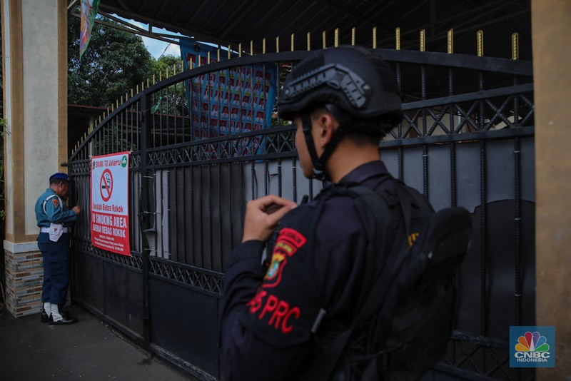 Petugas keamaan melakukan penjagaan pada pintu masuk usai terjadi ledakan di SMAN 72, Jakarta, Jumat (7/11/2025). (CNBC Indonesia/Faisal Rahman)