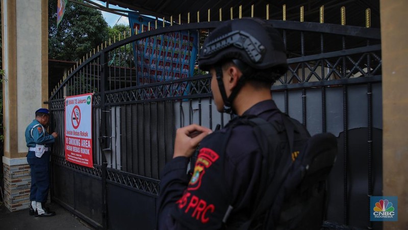Petugas keamaan melakukan penjagaan pada pintu masuk usai terjadi ledakan di SMAN 72, Jakarta, Jumat (7/11/2025). (CNBC Indonesia/Faisal Rahman)