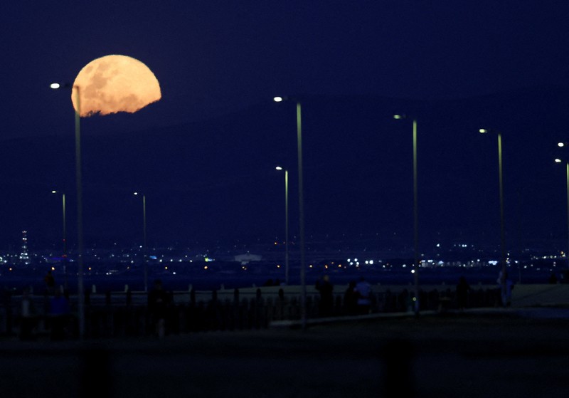 Pesawat melintasi bulan supermoon di Aguimes, Pulau Gran Canaria, Spanyol, 5 November 2025. (REUTERS/Borja Suarez)