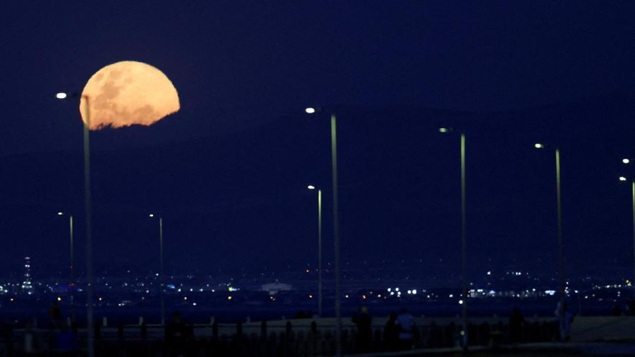 Pesawat melintasi bulan supermoon di Aguimes, Pulau Gran Canaria, Spanyol, 5 November 2025. (REUTERS/Borja Suarez)