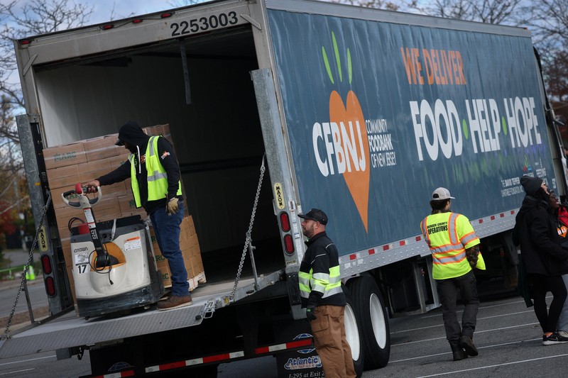 Para relawan memuat kotak-kotak makanan ke dalam mobil selama acara yang diadakan oleh Community FoodBank of New Jersey bekerja sama dengan Bergen County untuk mengirimkan bantuan makanan darurat kepada pekerja Federal dan penerima SNAP di tengah penutupan pemerintah AS di Leonia, New Jersey, AS, 6 November 2025. (REUTERS/Mike Segar)