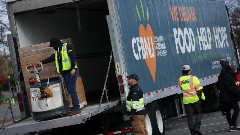 Para relawan memuat kotak-kotak makanan ke dalam mobil selama acara yang diadakan oleh Community FoodBank of New Jersey bekerja sama dengan Bergen County untuk mengirimkan bantuan makanan darurat kepada pekerja Federal dan penerima SNAP di tengah penutupan pemerintah AS di Leonia, New Jersey, AS, 6 November 2025. (REUTERS/Mike Segar)