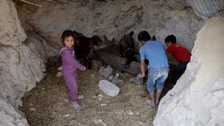 Di desa al-Latamna di pedesaan Hama, warga Suriah tinggal bersama keluarganya di dalam gua yang dipahat di lereng bukit berbatu. (REUTERS/Khalil Ashawi)