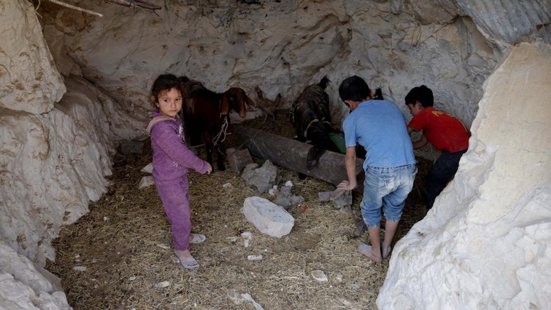 Di desa al-Latamna di pedesaan Hama, warga Suriah tinggal bersama keluarganya di dalam gua yang dipahat di lereng bukit berbatu. (REUTERS/Khalil Ashawi)