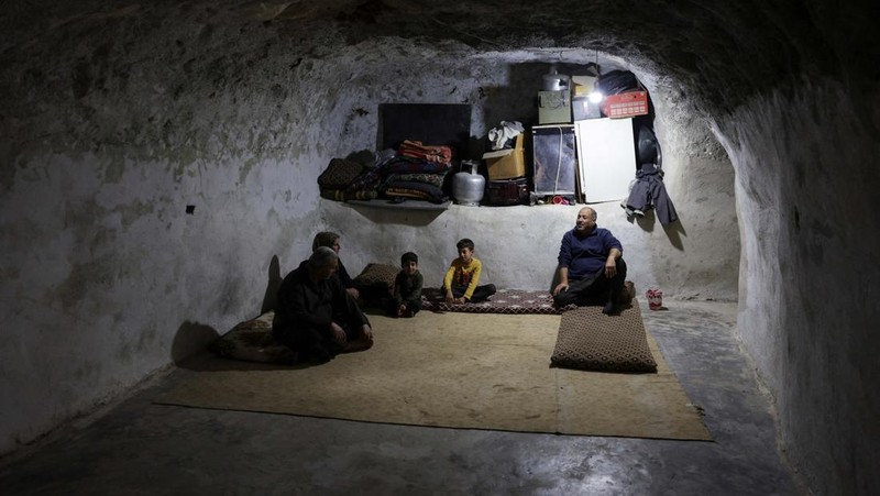 Di desa al-Latamna di pedesaan Hama, warga Suriah tinggal bersama keluarganya di dalam gua yang dipahat di lereng bukit berbatu. (REUTERS/Khalil Ashawi)