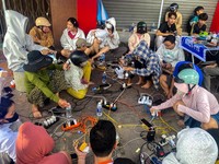 Warga mengisi daya ponsel dan perangkat elektronik mereka setelah pemadaman listrik akibat Topan Kalmaegi di Phu My, Provinsi Gia Lai, Vietnam tengah, 7 November 2025. (REUTERS/Thinh Nguyen)