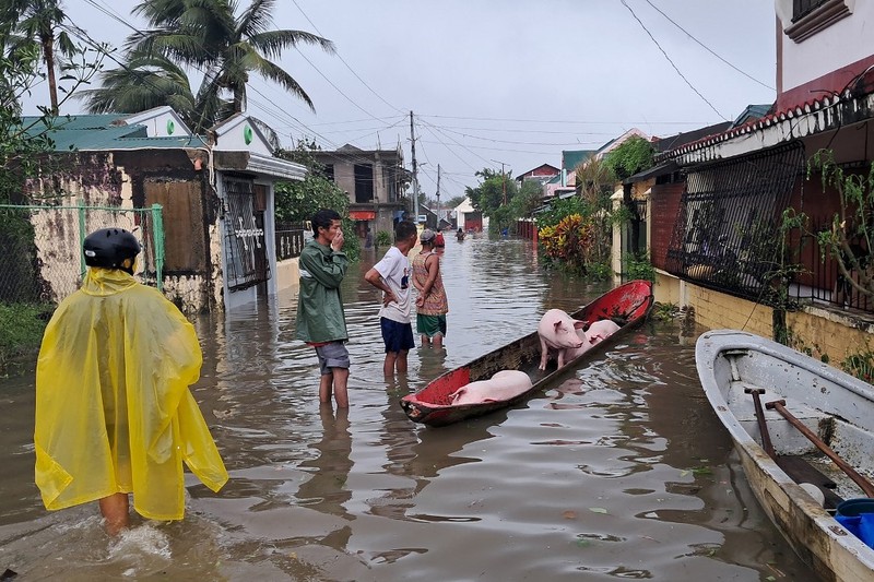Seorang wanita berjalan melalui gang yang banjir setelah Topan Fung-wong melanda Kota Dagupan, Pangasinan, Filipina, 10 November 2025. (REUTERS/Noel Celis)