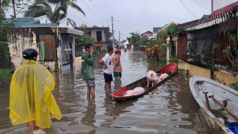 Seorang wanita berjalan melalui gang yang banjir setelah Topan Fung-wong melanda Kota Dagupan, Pangasinan, Filipina, 10 November 2025. (REUTERS/Noel Celis)