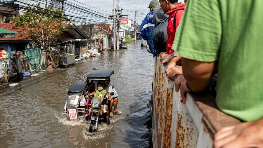 Seorang wanita berjalan melalui gang yang banjir setelah Topan Fung-wong melanda Kota Dagupan, Pangasinan, Filipina, 10 November 2025. (REUTERS/Noel Celis)