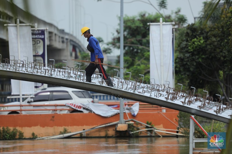 Pekerja melewati proyek Wisata Air Kalimalang di kawasan KH Noer Ali, Kalimalang, Bekasi, Jawa Barat, Senin (10/11/2025). (CNBC Indonesia/Tri Susilo)
