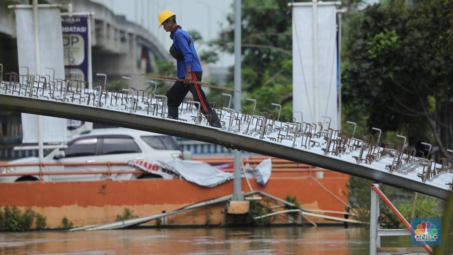 Pekerja melewati proyek Wisata Air Kalimalang di kawasan KH Noer Ali, Kalimalang, Bekasi, Jawa Barat, Senin (10/11/2025). (CNBC Indonesia/Tri Susilo)