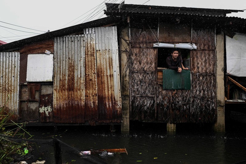 Seorang wanita berjalan melalui gang yang banjir setelah Topan Fung-wong melanda Kota Dagupan, Pangasinan, Filipina, 10 November 2025. (REUTERS/Noel Celis)