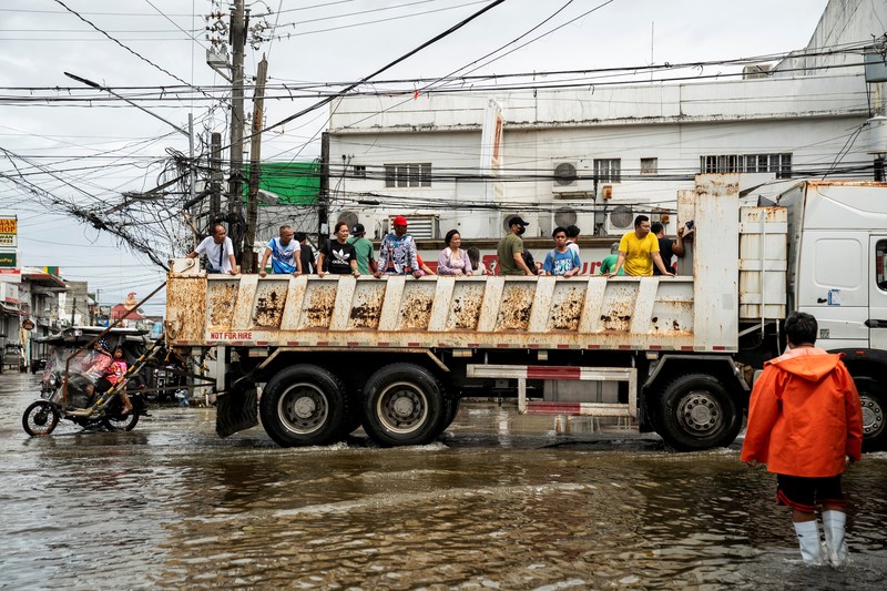 Seorang wanita berjalan melalui gang yang banjir setelah Topan Fung-wong melanda Kota Dagupan, Pangasinan, Filipina, 10 November 2025. (REUTERS/Noel Celis)
