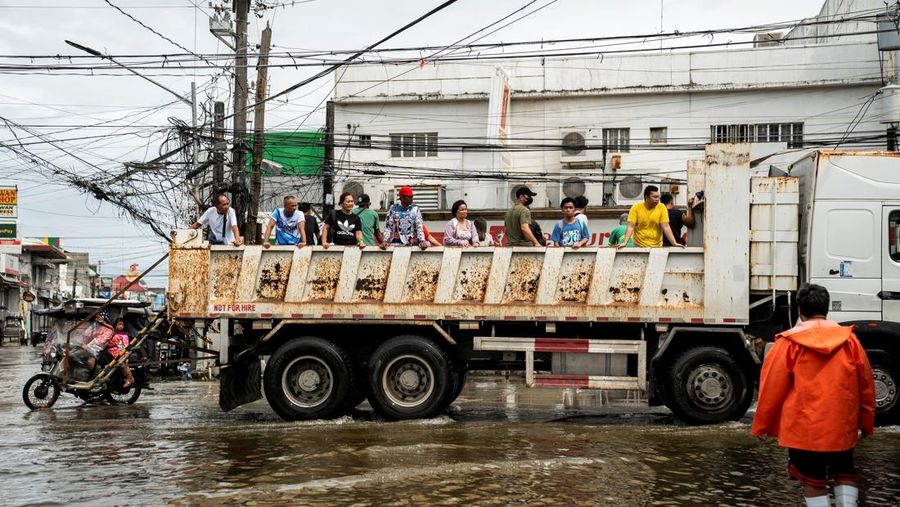 Seorang wanita berjalan melalui gang yang banjir setelah Topan Fung-wong melanda Kota Dagupan, Pangasinan, Filipina, 10 November 2025. (REUTERS/Noel Celis)