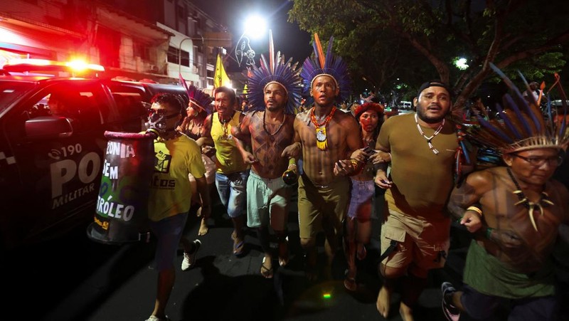 Masyarakat adat berjalan bersama saat berpartisipasi dalam demonstrasi di sela-sela Konferensi Perubahan Iklim PBB (COP30), di Belém, Brasil, 11 November 2025. (REUTERS/Anderson Coelho)