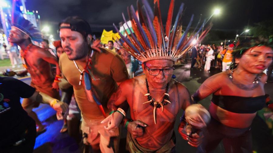 Masyarakat adat berjalan bersama saat berpartisipasi dalam demonstrasi di sela-sela Konferensi Perubahan Iklim PBB (COP30), di Belém, Brasil, 11 November 2025. (REUTERS/Anderson Coelho)