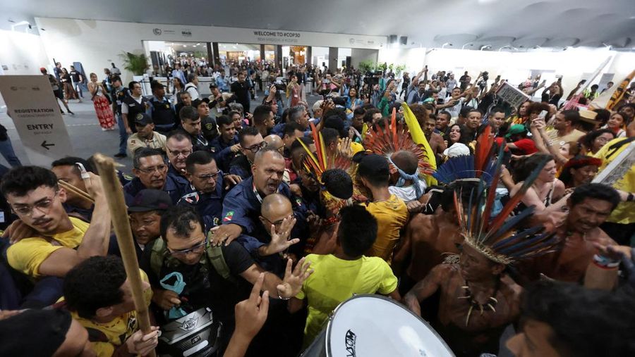 Masyarakat adat berjalan bersama saat berpartisipasi dalam demonstrasi di sela-sela Konferensi Perubahan Iklim PBB (COP30), di Belém, Brasil, 11 November 2025. (REUTERS/Anderson Coelho)