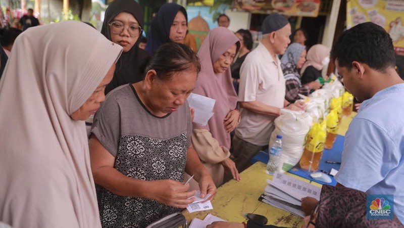 Warga mengantre untuk mengambil bantuan pangan gratis di Balai RW 03 Kelurahan Menteng, Jakarta, Rabu (12/11/2025). (CNBC Indonesia/Muhammad Sabki)