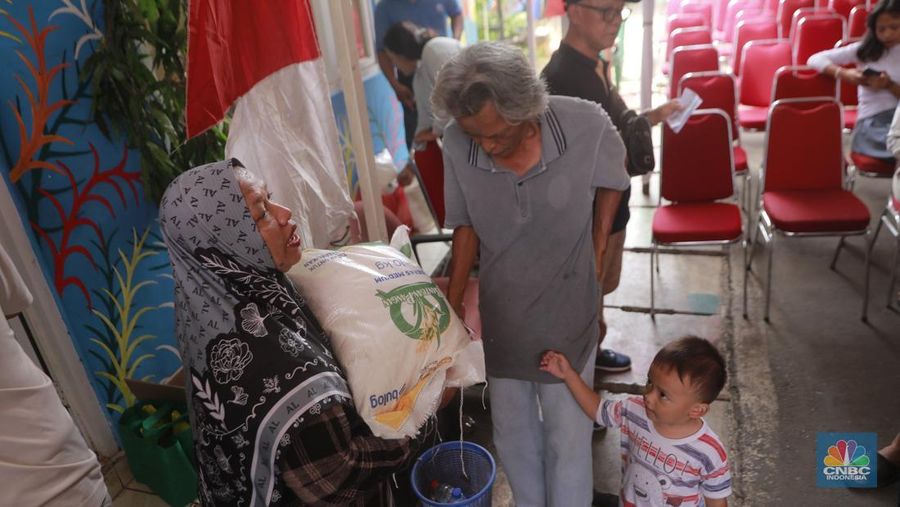 Warga mengantre untuk mengambil bantuan pangan gratis di Balai RW 03 Kelurahan Menteng, Jakarta, Rabu (12/11/2025). (CNBC Indonesia/Muhammad Sabki)