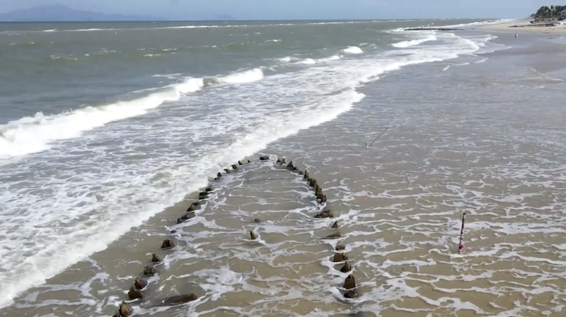 Erosi pantai parah yang disebabkan oleh Topan Kalmaegi pada Sabtu mengungkap kerangka kapal dagang kayu berusia berabad-abad di Pantai Tan Thanh, kawasan kota kuno Hoi An yang terdaftar sebagai Warisan Dunia UNESCO. (Tangkapan Layar Video Reuters/TRAN ANH PHUONG)